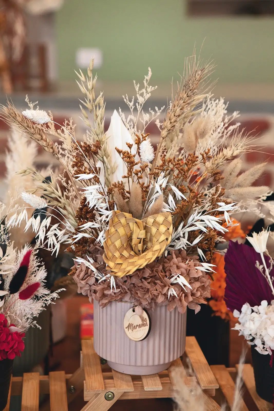 Large cream and gold dried flower arrangement in a ribbed vase