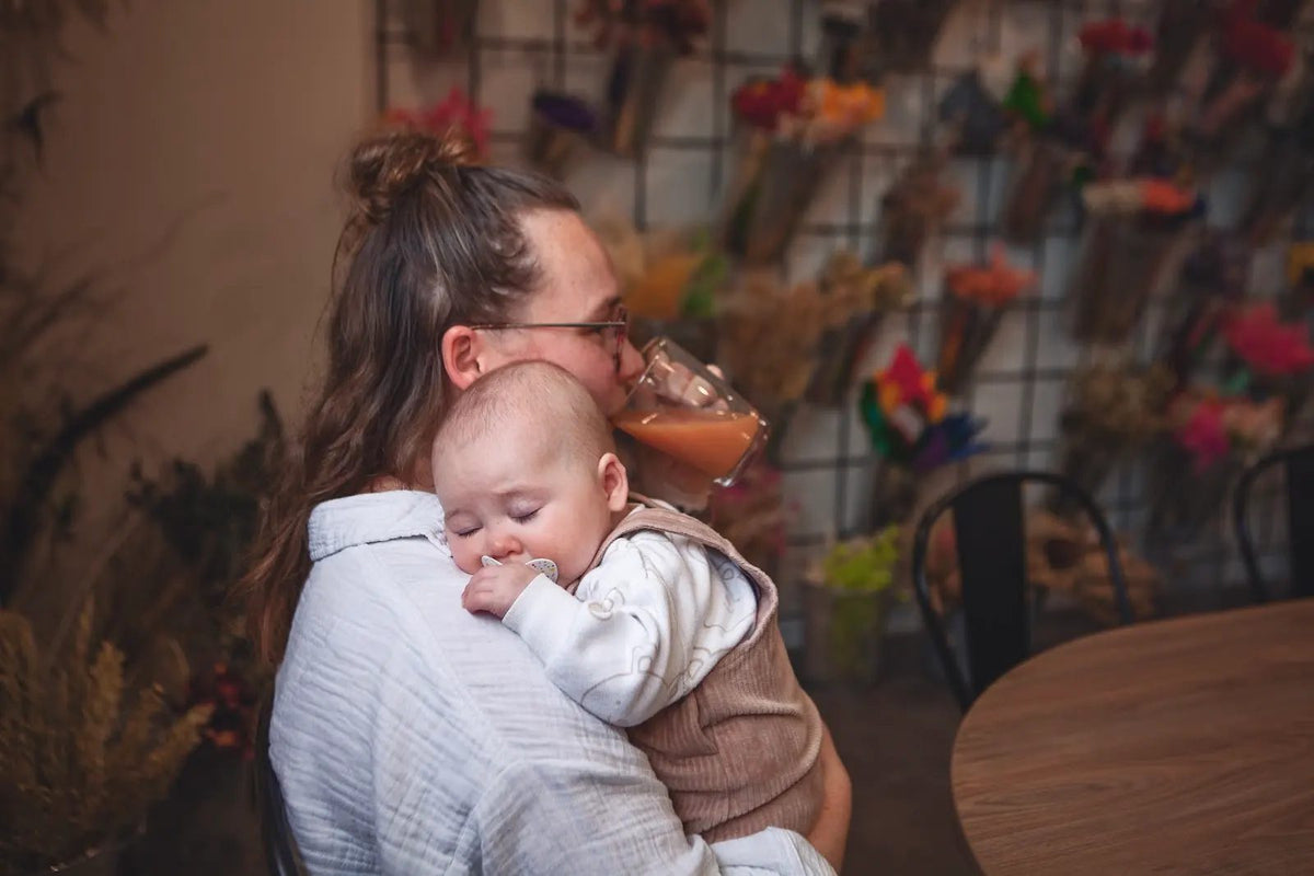 A mum cuddles her baby at the Petals and Prams workshop